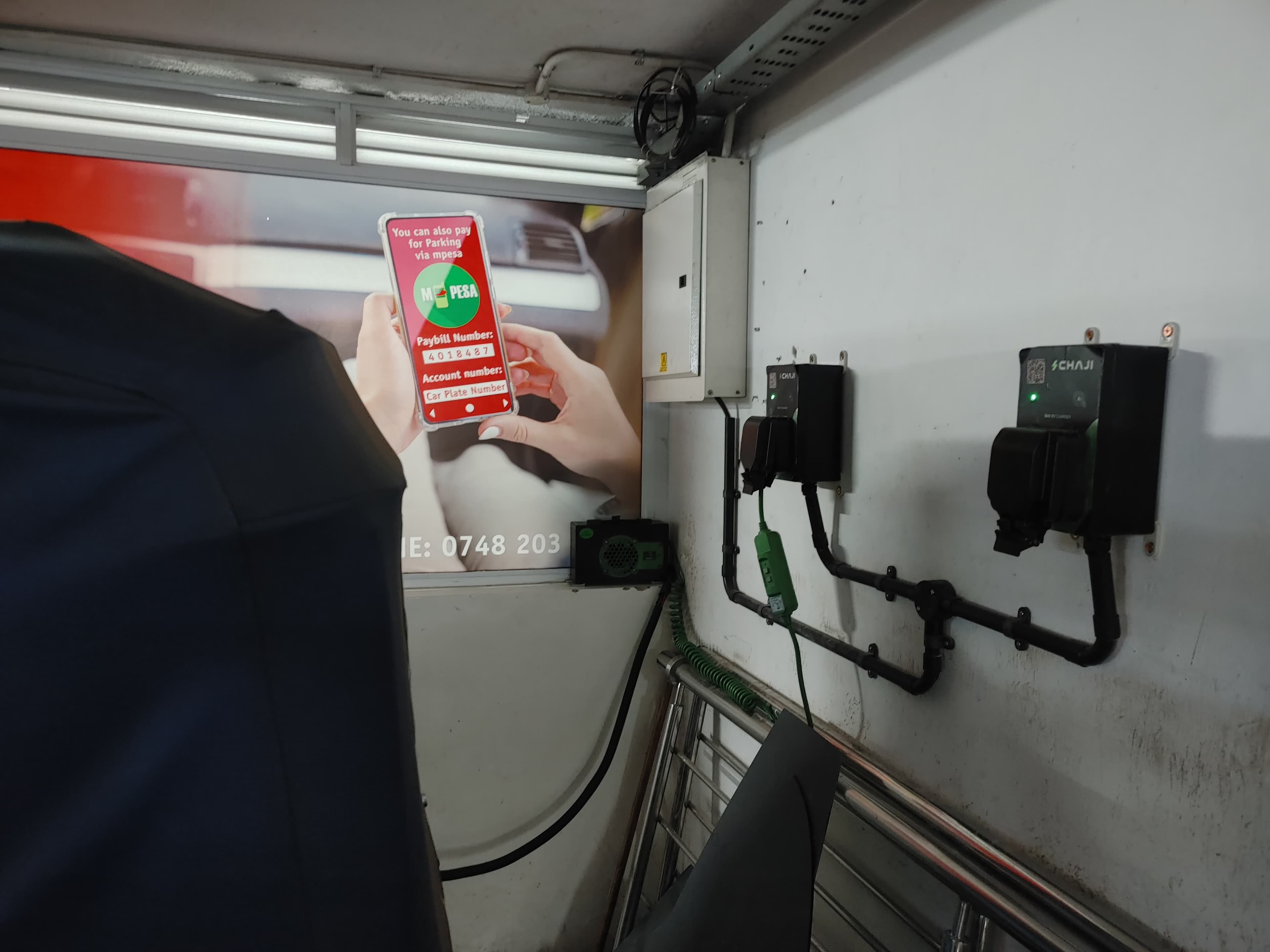 A rider paying for charging through M-Pesa next to a Chaji charging unit